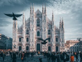 A panoramic view of Milan’s cityscape, featuring the iconic Milan Cathedral (Duomo di Milano) and the bustling streets filled with historic and modern architecture.