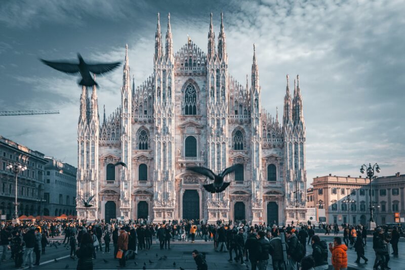 A panoramic view of Milan’s cityscape, featuring the iconic Milan Cathedral (Duomo di Milano) and the bustling streets filled with historic and modern architecture.